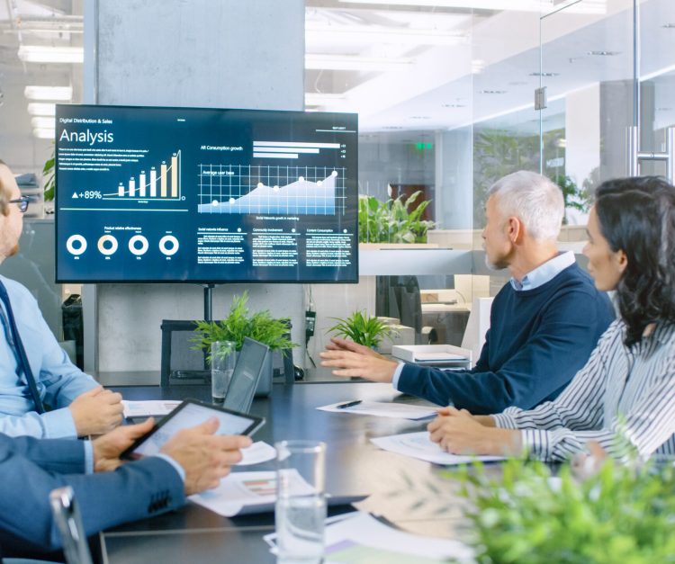 Board of Directors Has Annual Meeting, Diverse Group of Business People in the Modern Conference Room Discuss Statistics and Work Results. In the Background Projector Showing Company Growth.