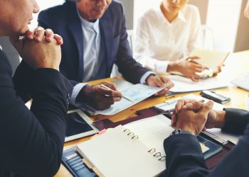 A group of business people are meeting to analyze data for marketing plan